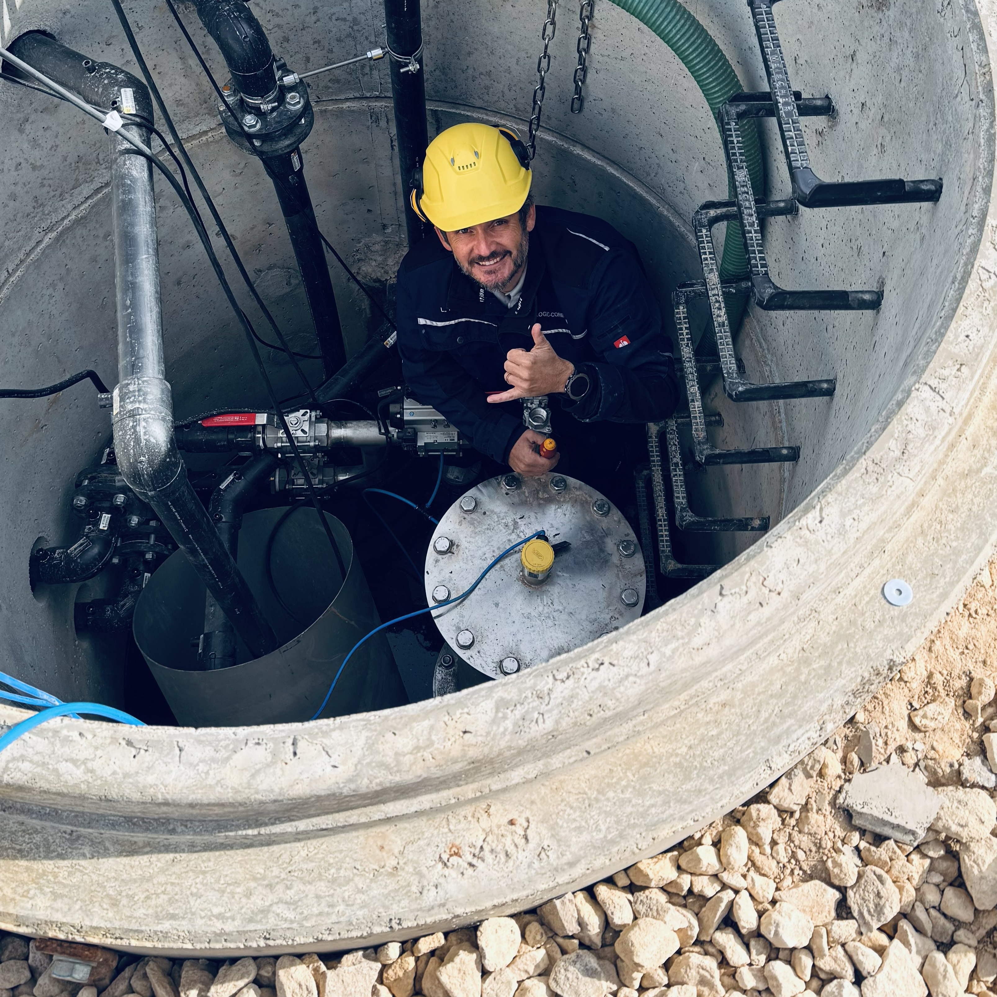 Techniker in der Inbetriebnahme mit Notebook und Schutzhelm